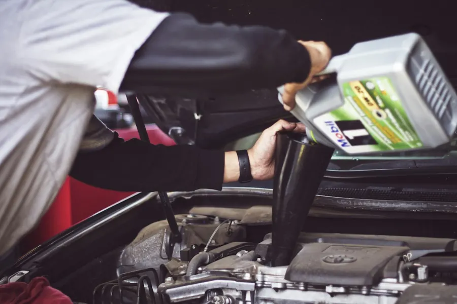 Mechanic topping up engine oil